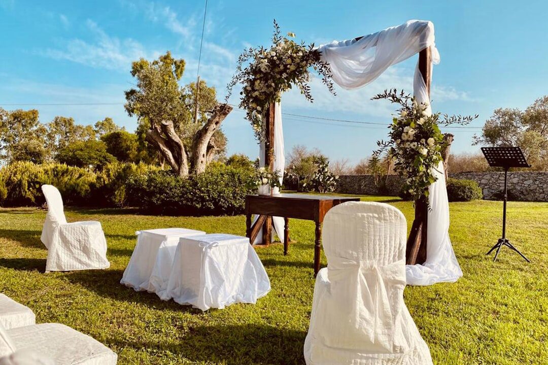 Decoración de una boda de lujo con detalles dorados y arco floral al aire libre